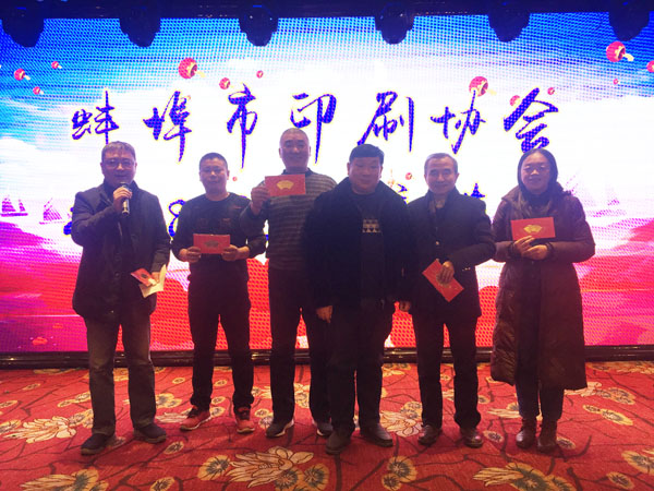 蚌埠市印刷協會副會長、蚌埠市興順彩印廠總經理周興平（中）登臺抽獎，并與獲獎人員合影留念