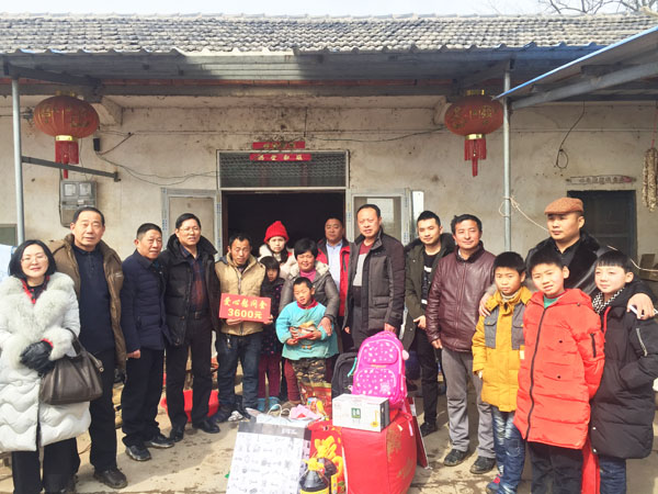 商會愛心慰問團正在張澤家全家（圖中），并與他們合影