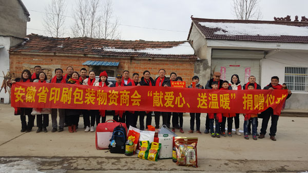商會愛心尉問團正在慰問宋祝英母子（圖中），并與他們合影留念