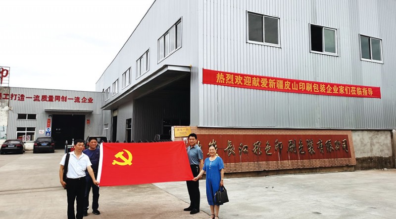 參加此次活動的四位黨員手握鮮紅的黨旗在長江公司大門前合影留念